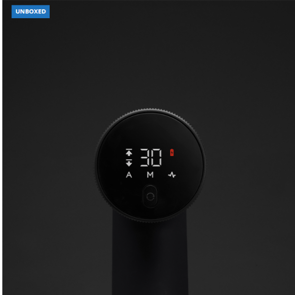 Black handheld device with digital display on a black background, labeled 'UNBOXED'.