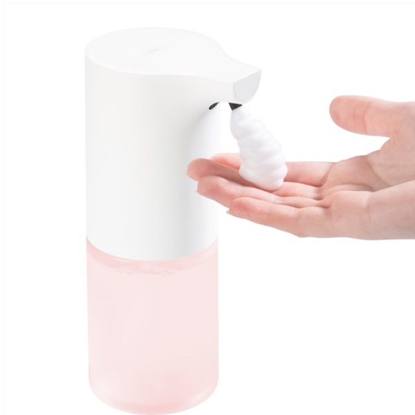 Hand soap dispenser with pink base and white top, dispensing soap into a hand.