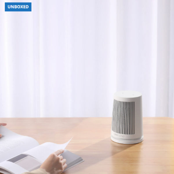Air purifier on a table with a person reading a book in the background