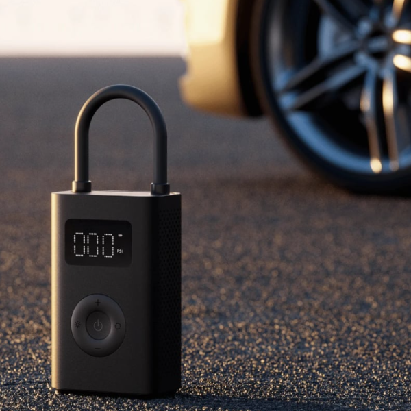 Black electronic lock with digital display on a textured surface, possibly near a vehicle.