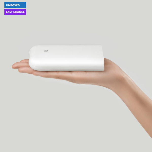 White rectangular device held in a hand against a light gray background