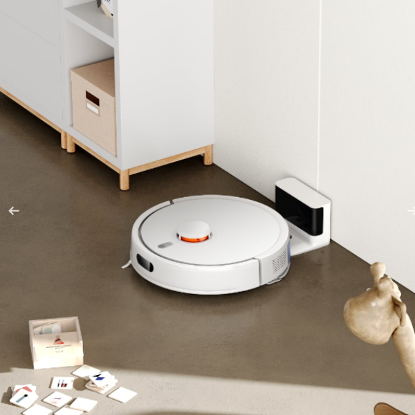Robotic vacuum cleaner cleaning a room with scattered items on the floor.