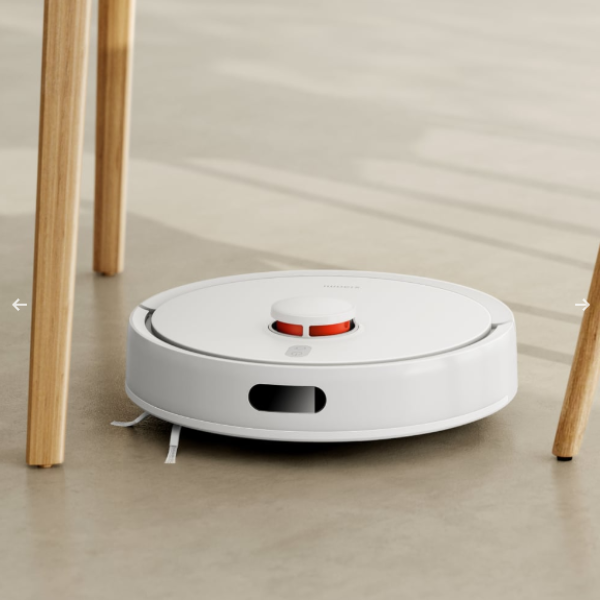 White robot vacuum cleaner on a light wooden floor.