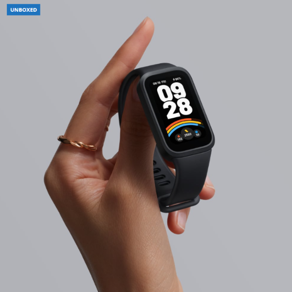 Hand holding a black smartwatch with a gray background