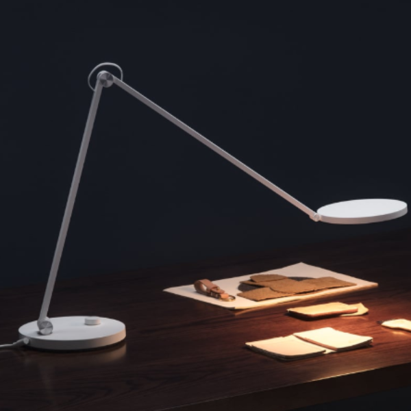 Modern desk lamp on a dark surface with a dark background