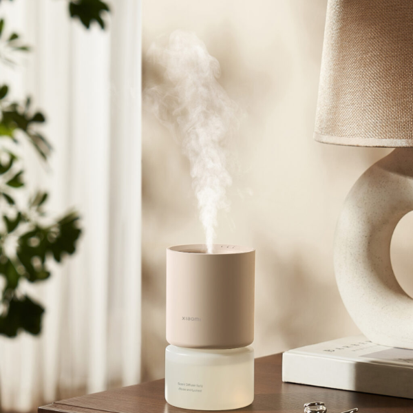 Humidifier on a table with a lamp and plant in the background