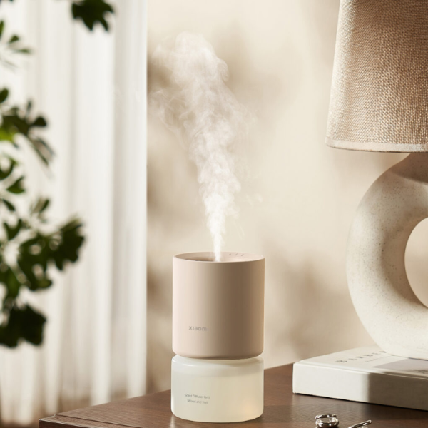 Humidifier on a table with a lamp and plant in the background