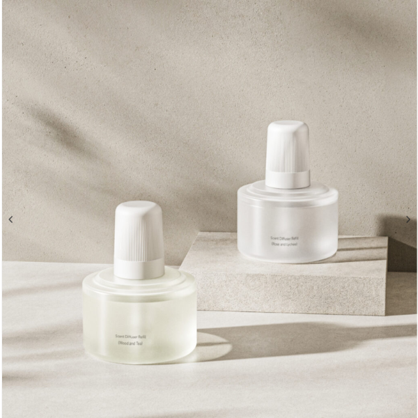 Two white skincare bottles on a neutral background