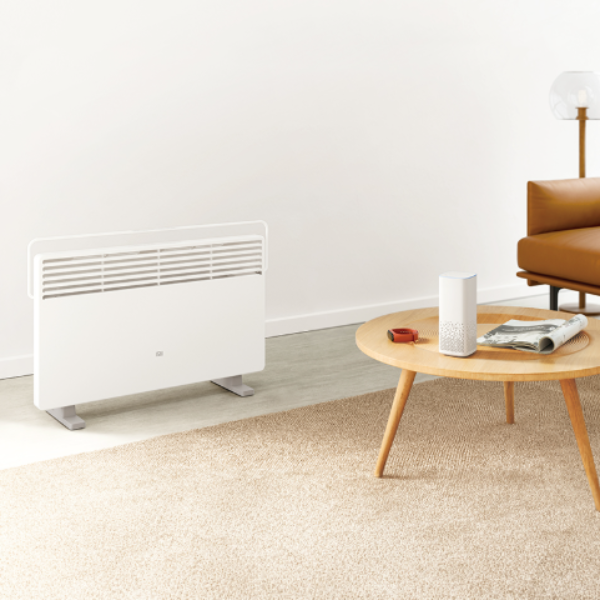 White radiator on a wall in a living room with a coffee table and sofa.