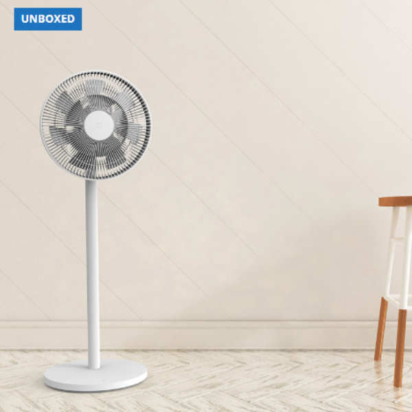 White standing fan on a light wooden floor with a neutral wall background