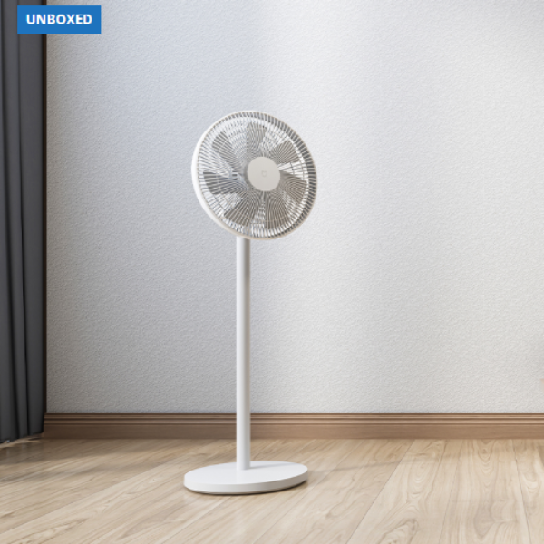 White standing fan on a wooden floor with a plain wall background