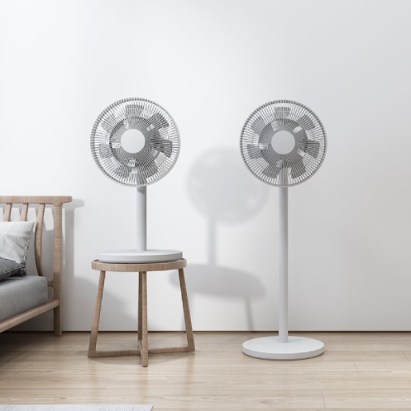Two modern standing fans on a wooden floor with a minimalistic background
