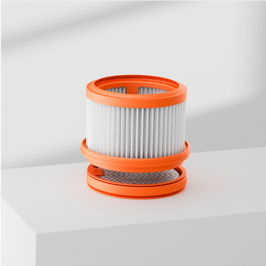 Stack of vacuum filter cartridges with orange rims on a white surface