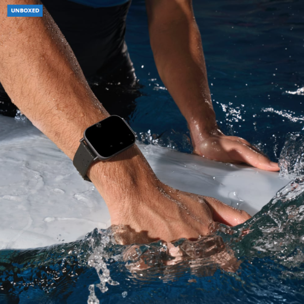 Person wearing a smartwatch in water, with 'UNBOXED' branding.