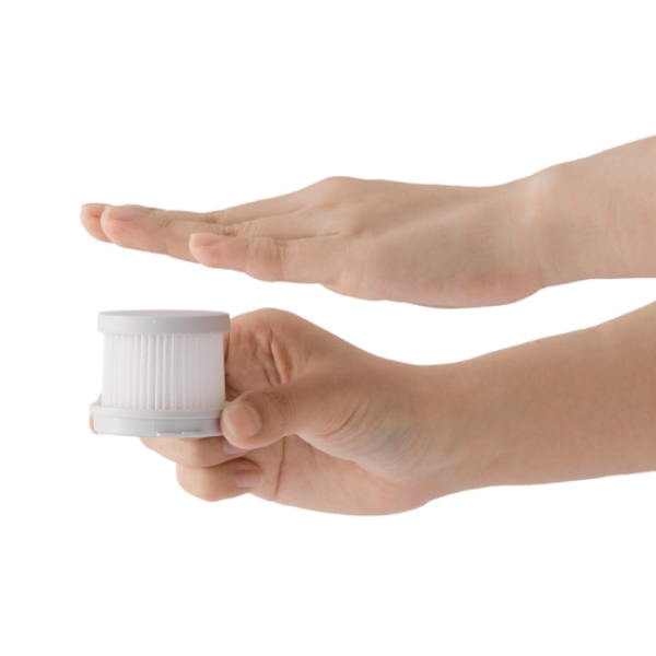 Hand holding a small white cylindrical object against a white background