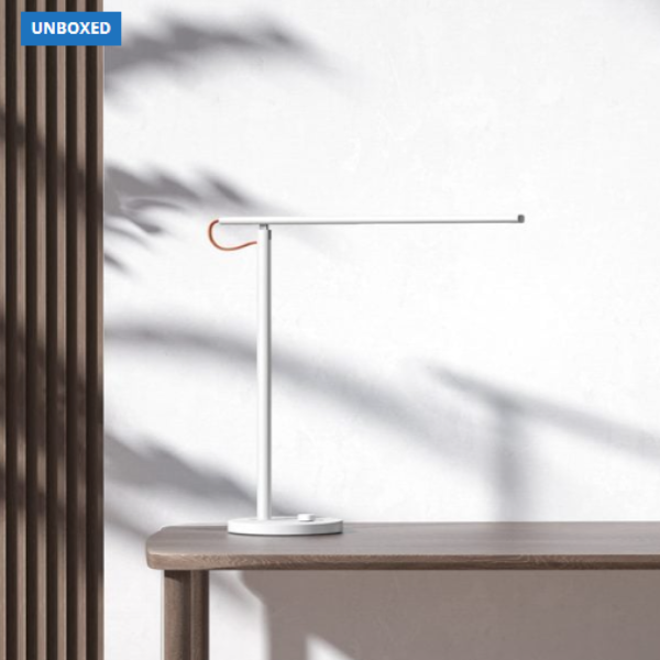 Modern desk lamp on a wooden surface with a blurred background