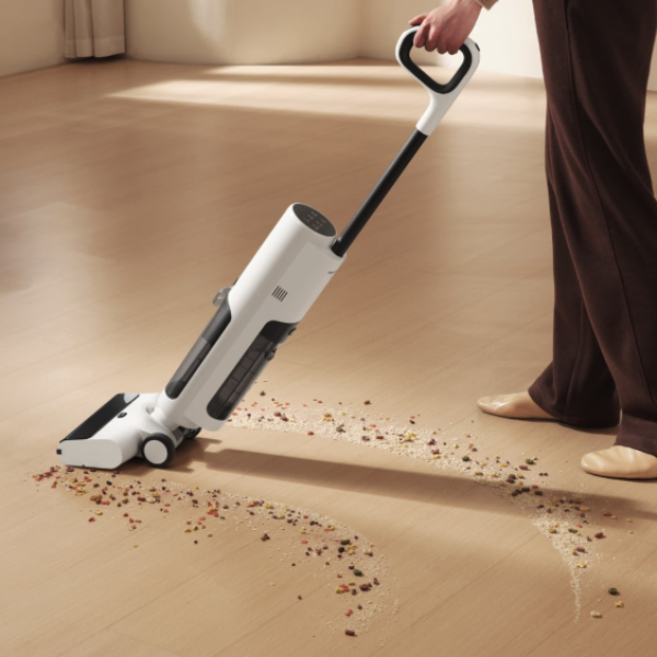 Person using a handheld vacuum cleaner on a wooden floor